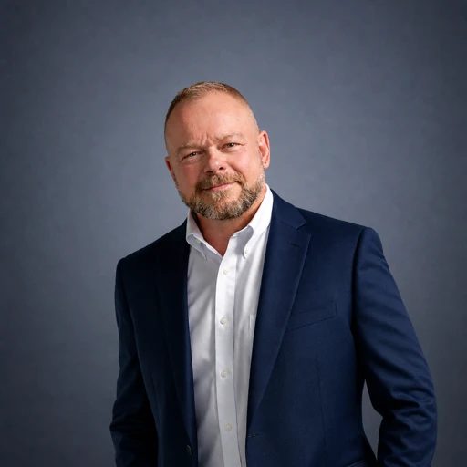 Chuck Kinney in a navy jacket against a dark gray background