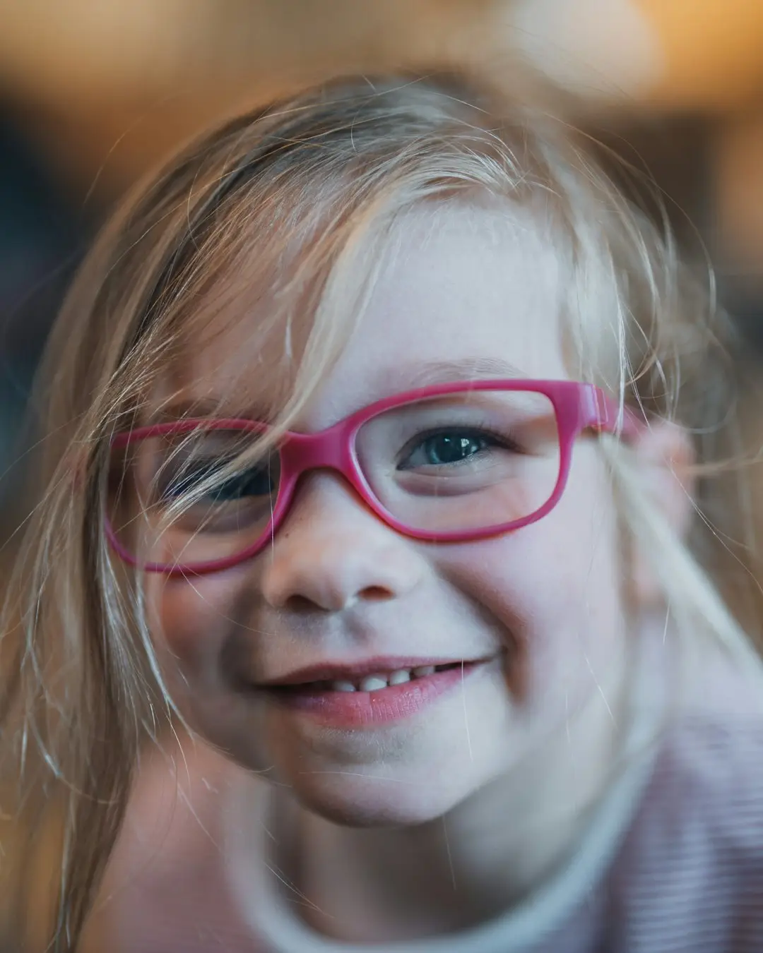 A smiling young girl wearing glasses, a sign of good children's eye health care