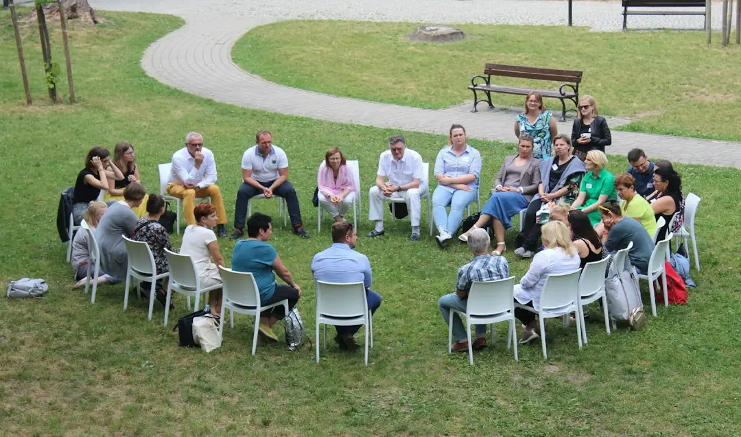 A recovery support group sitting in a circle outdoors