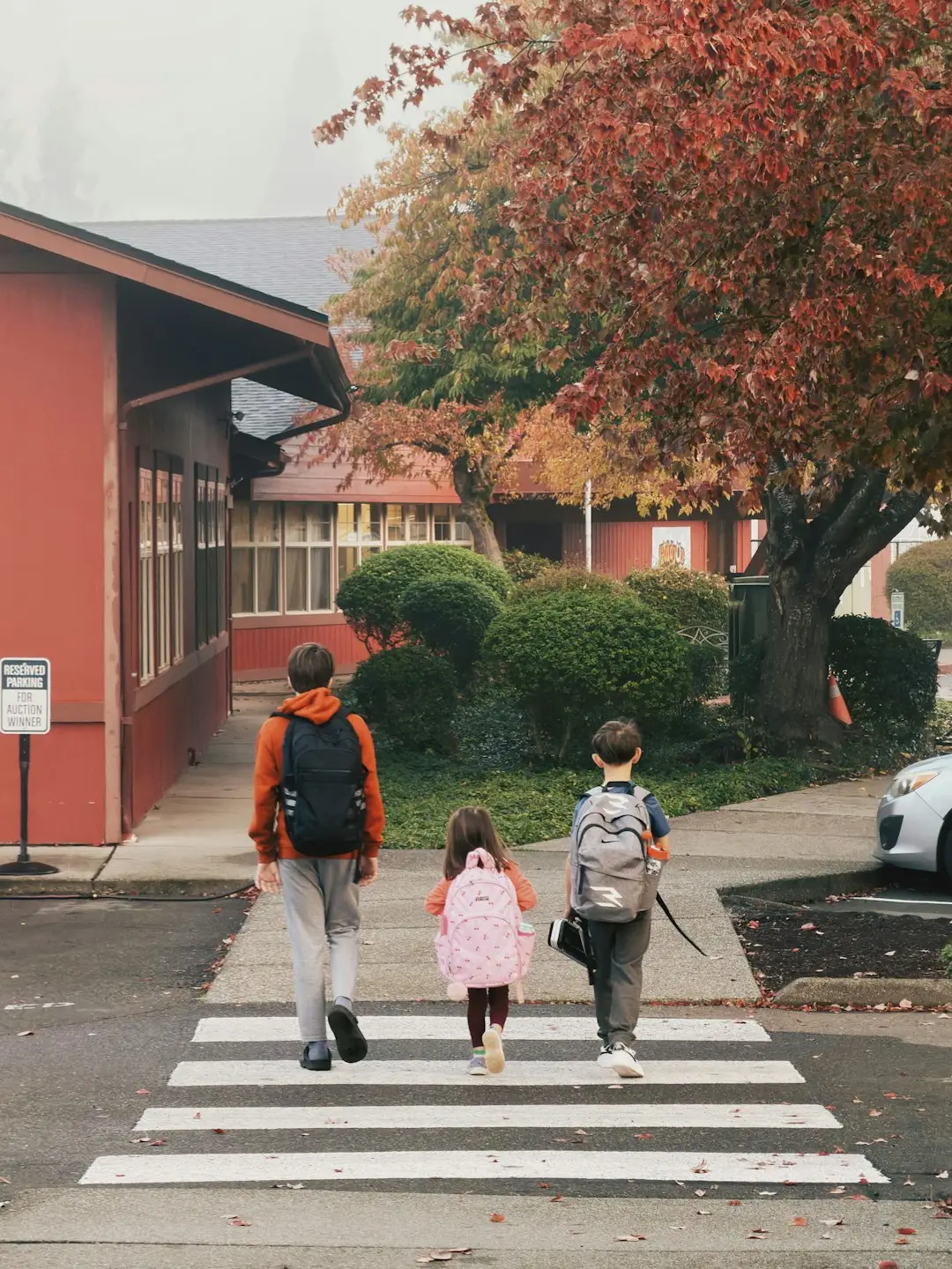 Three children with backpacks walking to school, ready after a back-to-school health checklist